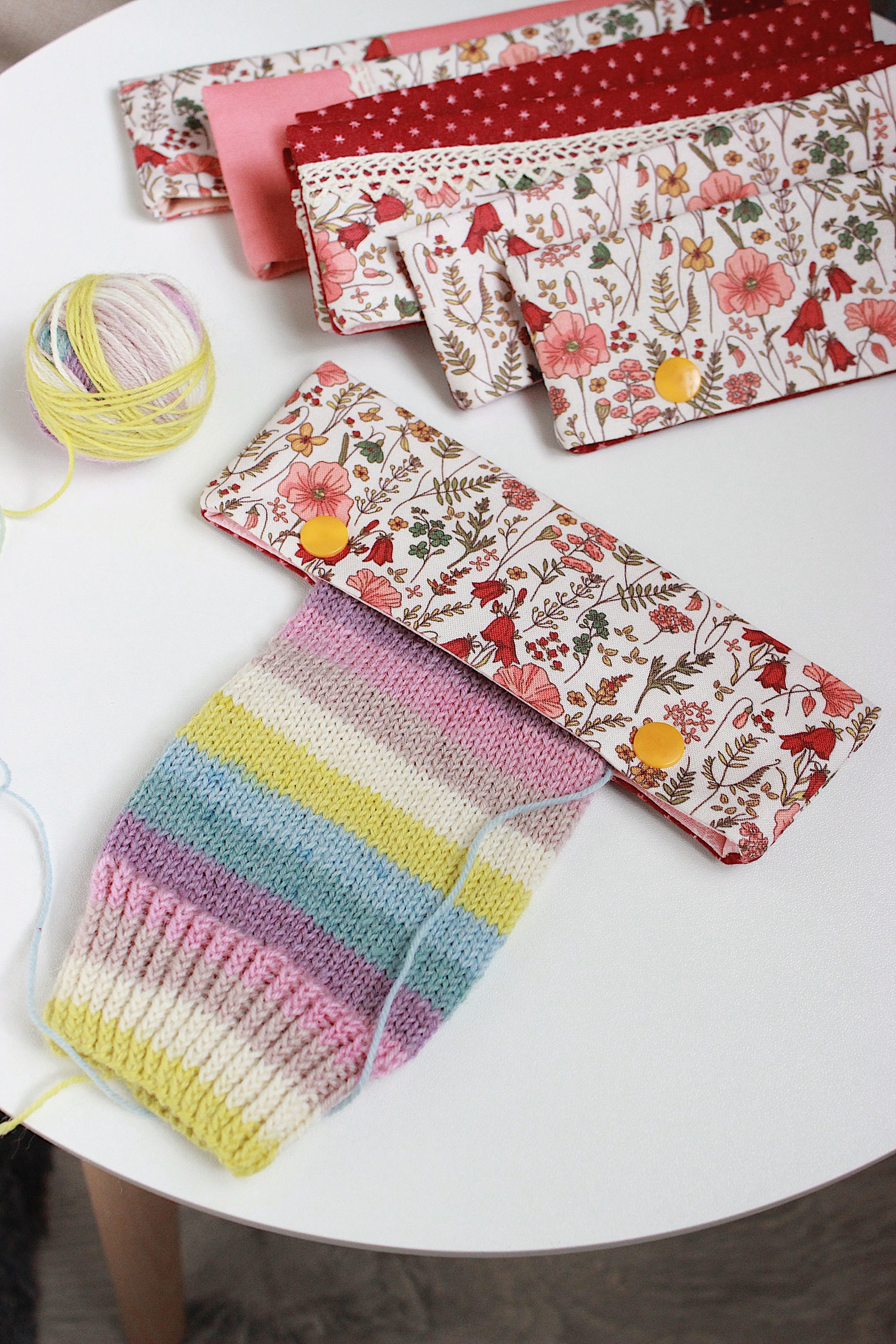 Colorful knitted item with floral-patterned cases on a white surface